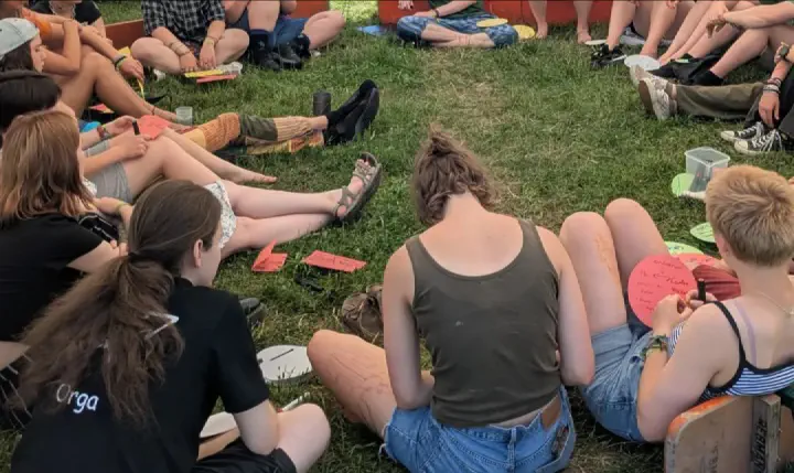 Menschen sitzen für einen Workshop im Kreis auf dem Boden